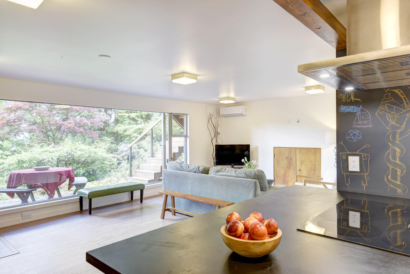 Living room and kitchen area in a Seattle basement ADU, offering open-plan design and natural light, remodeled by CB Construction