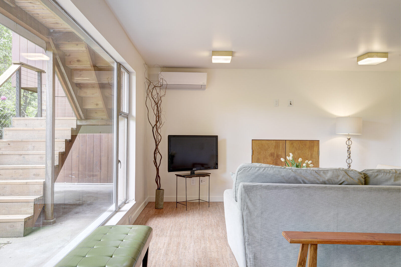 Living room area of a basement ADU in Seattle, remodeled by CB Construction, featuring large windows and modern decor Living room area of a basement ADU in Seattle, remodeled by CB Construction, featuring large windows and modern decor
