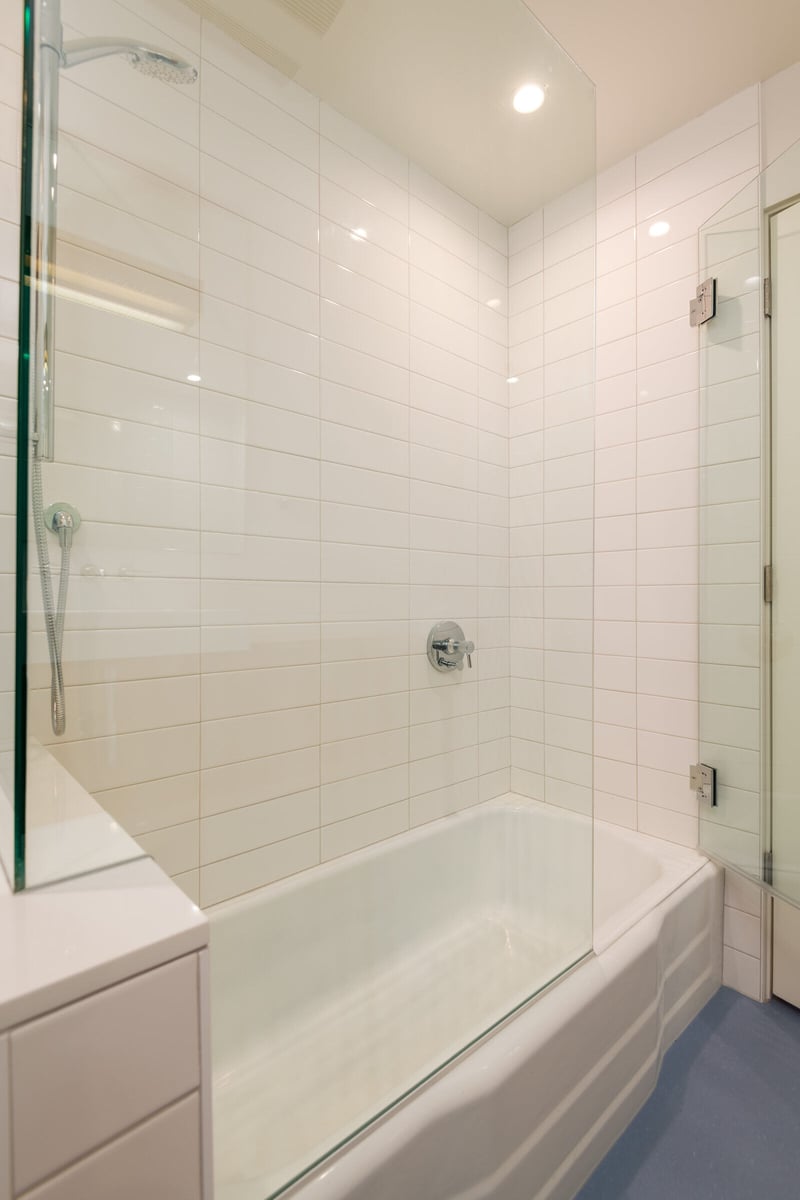 Glass shower enclosure with white tiles in a Seattle bathroom remodel by CB Construction
