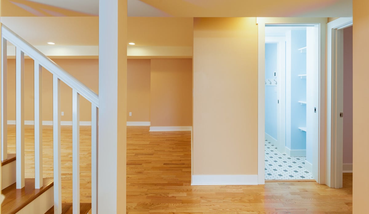 Remodeled basement with wood flooring and recessed lighting in Seattle by CB Construction