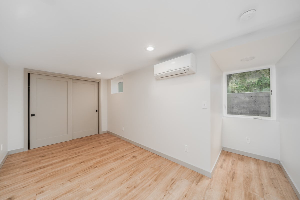Bright basement room with wood floors and recessed lighting in a Seattle ADU by CB Construction
