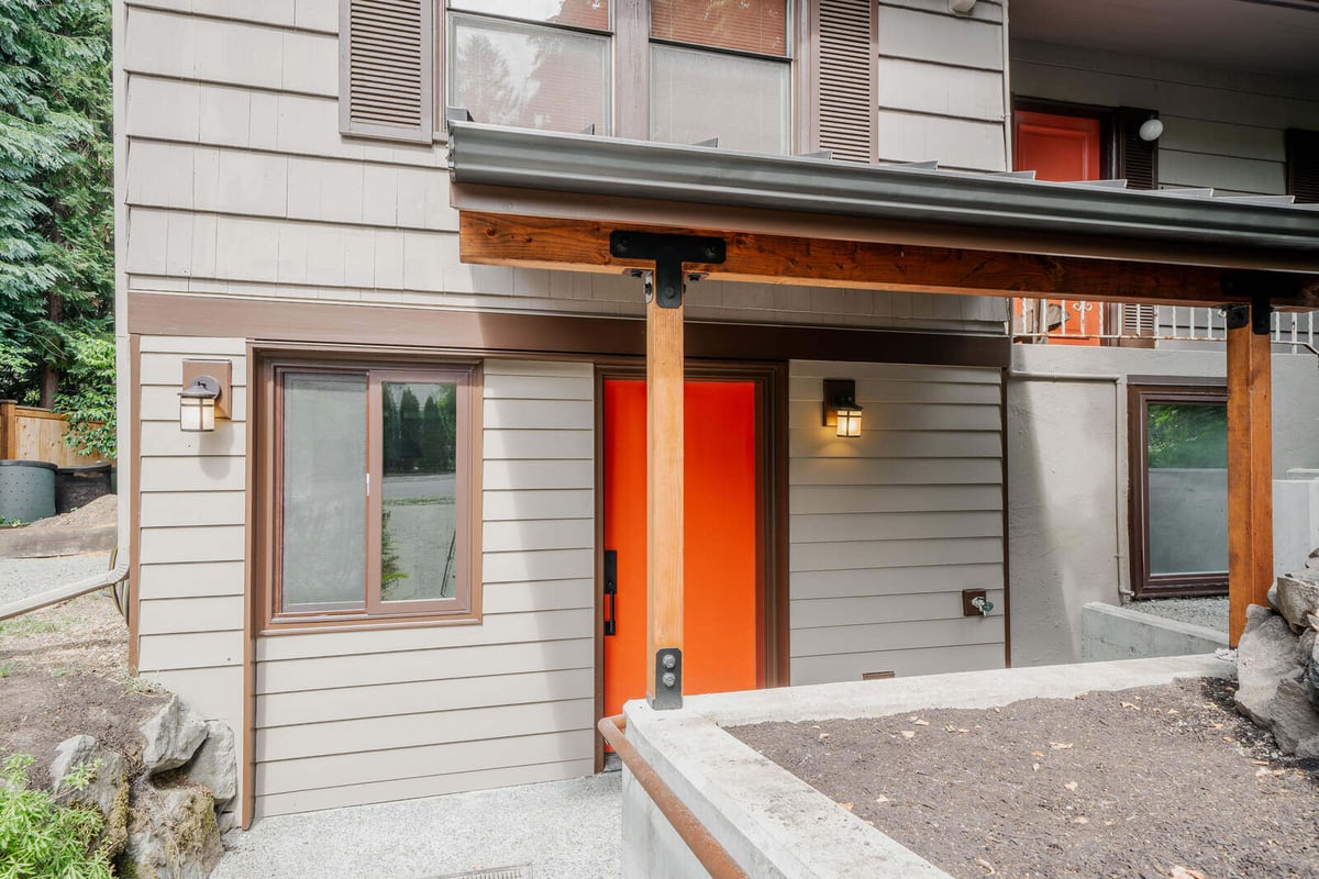 Exterior view of a Seattle ADU with a bright orange door and covered entryway, remodeled by CB Construction