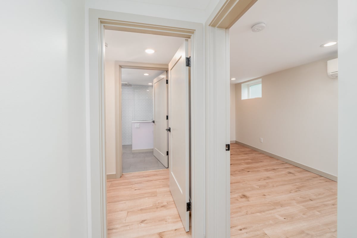 Hallway view leading to a modern bathroom in a Seattle basement ADU remodel by CB Construction