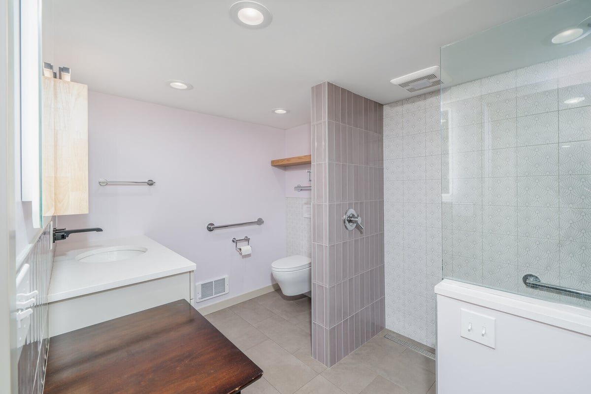 Modern Seattle ADU bathroom with a sleek vanity and large mirror, by CB Construction