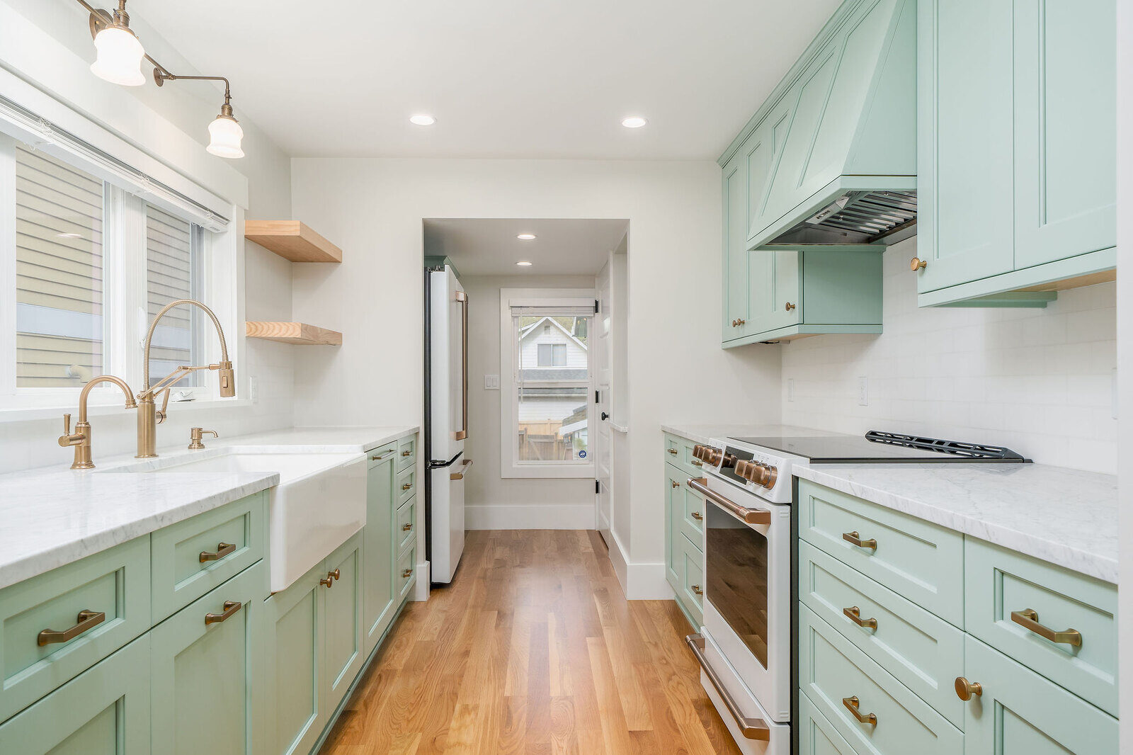 Modern kitchen remodel with mint green cabinets and marble countertops by CB Construction in Seattle