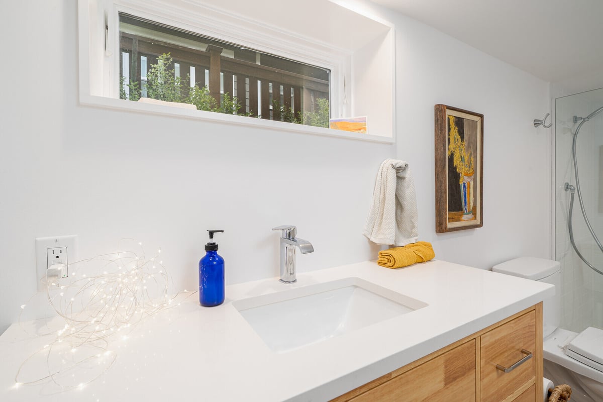 Modern bathroom vanity with wooden drawers in a remodeled basement by CB Construction in Seattle