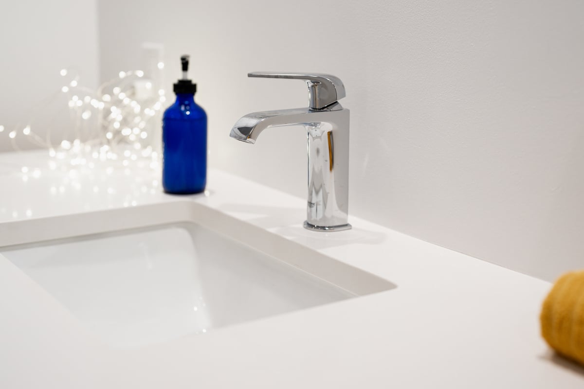 Polished chrome faucet on a white countertop in a CB Construction basement remodel, Seattle