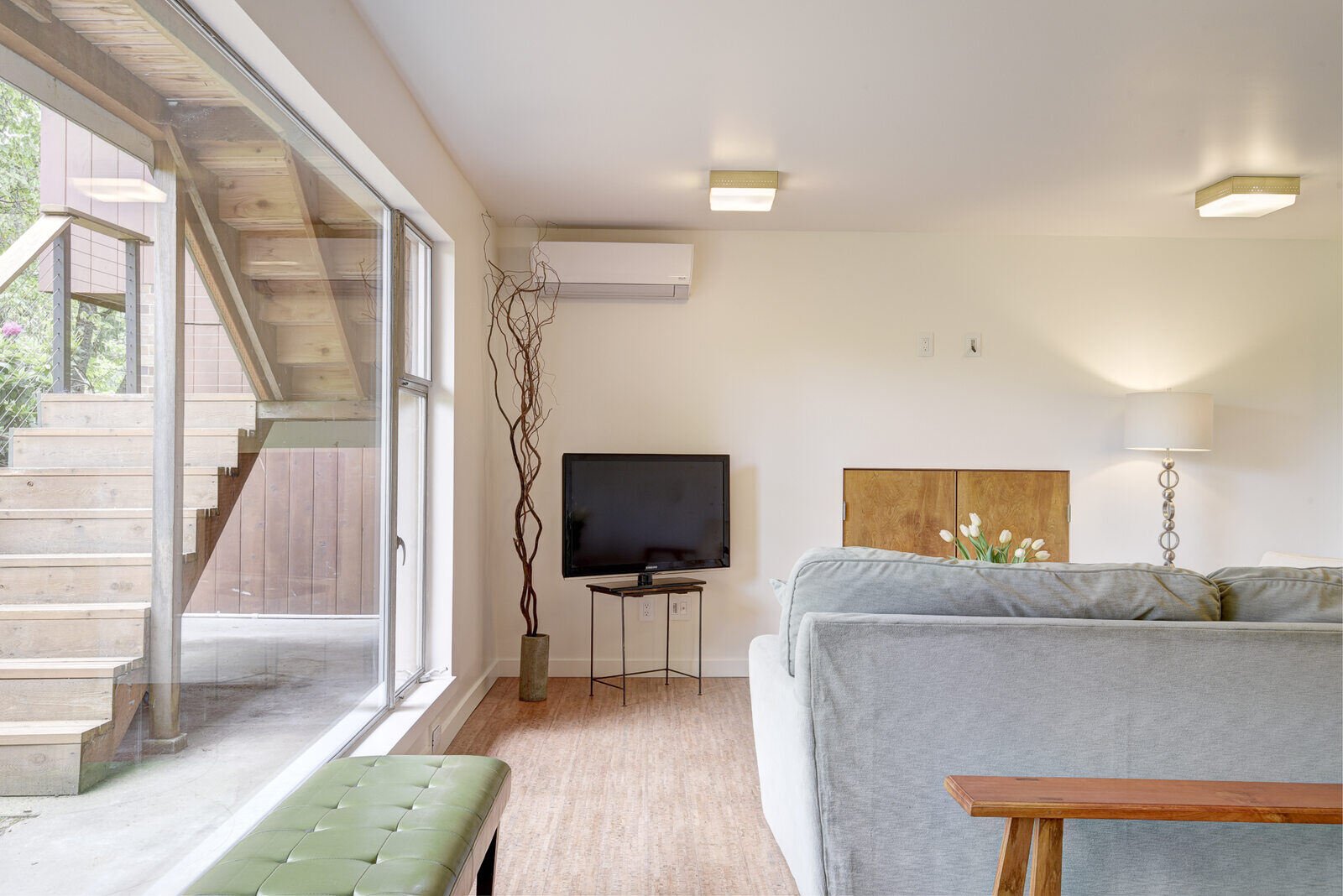 Living room area of a basement ADU in Seattle, remodeled by CB Construction, featuring large windows and modern decor