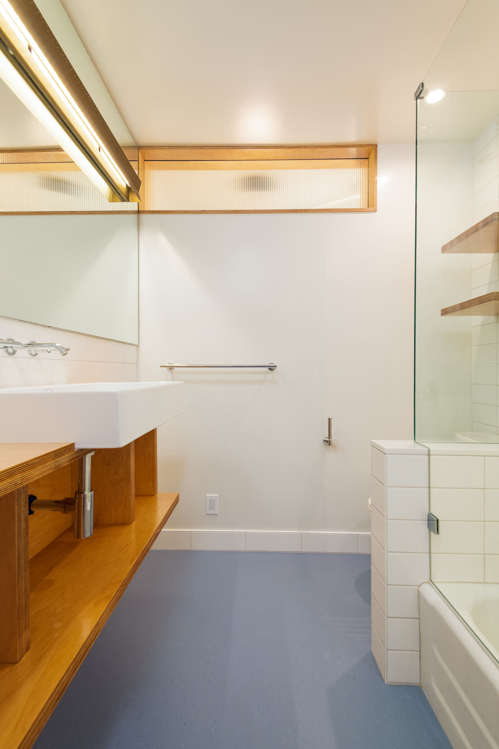 Bathroom remodel in Seattle by CB Construction with minimalist wood and tile accents