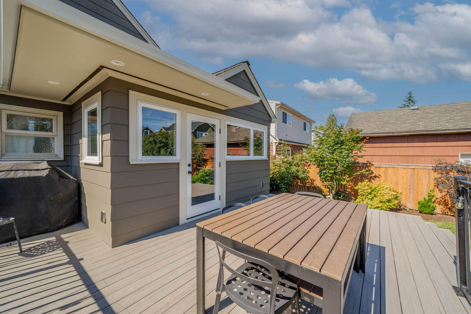 Seattle home with a remodeled backyard deck by CB Construction featuring outdoor seating and dining