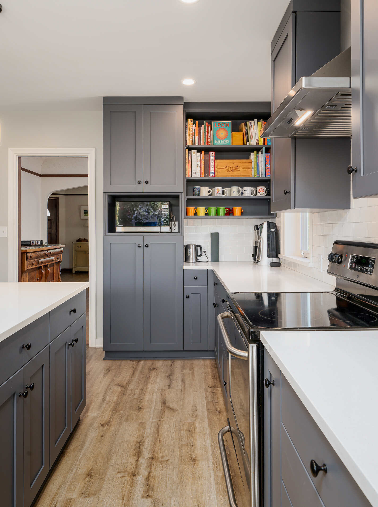 Seattle kitchen remodel by CB Construction with built-in microwave, grey cabinetry, and open shelves