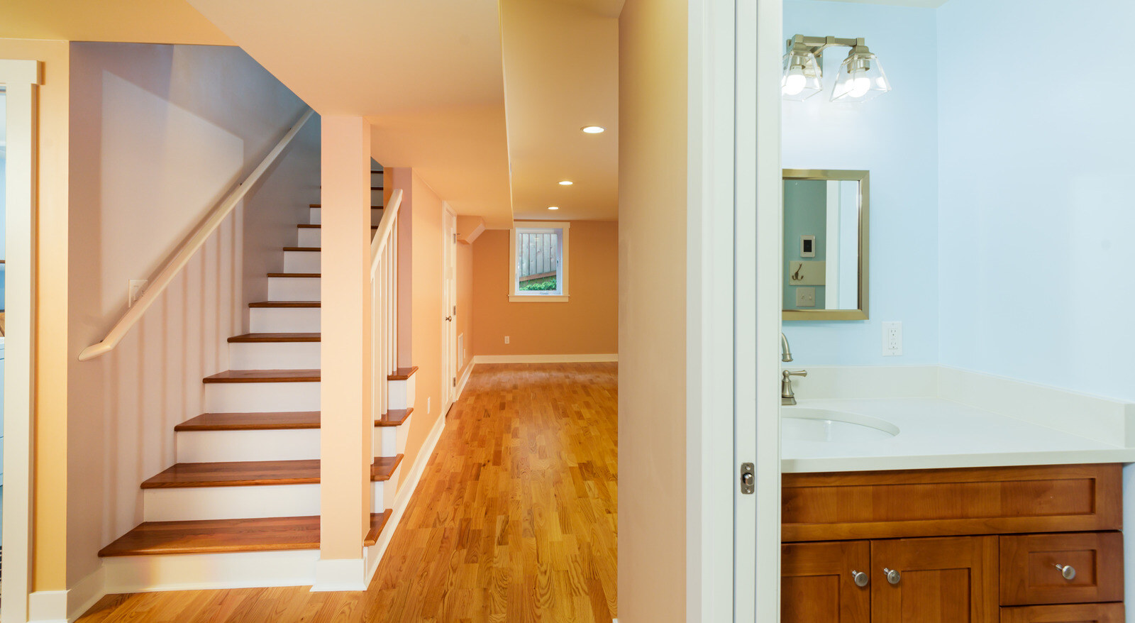 Laundry sink area with white cabinetry in a remodeled Seattle basement, by CB Construction